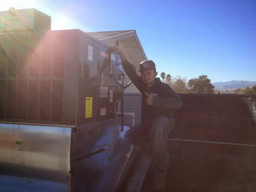 HVAC technician performing HVAC Inspection on a rooftop unit in Weston